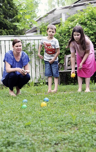 Nina van der Walt pelaa nuorimpien lastensa Asserin, 6, ja Adielin, 9, kanssa petankkia kotipihalla. Kuusihenkinen perhe aloittaa pian kesreissaamisen mutta aikoo pistyty hengellisiss tilaisuuksissa matkakohteissaan. Kuva: Ruut Ahonen