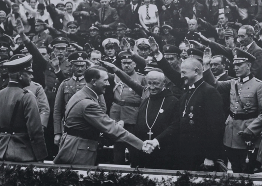 Kuvassa Adolf Hitler tervehtii saksalaisten kirkkojen piispoja. Kuvan arvioidaan otetun 1930-luvulla. (Wikipedia) 