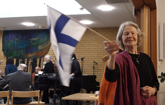 Mntn ylistystapahtumaan saapui vke mys lhiseuduilta, kuten Keuruulta. Pirjo Pulli oli ottanut mukaansa Suomen lipun. Taustalla musisoivat Jukka Tolonen ja Juhani Aaltonen. (Kirsi-Klaudia Kangas) 