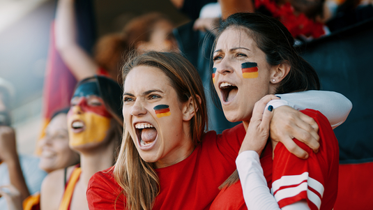 Kuvassa nuoria aikuisia saksalaisessa jalkapallokatsomossa. (Shutterstock)